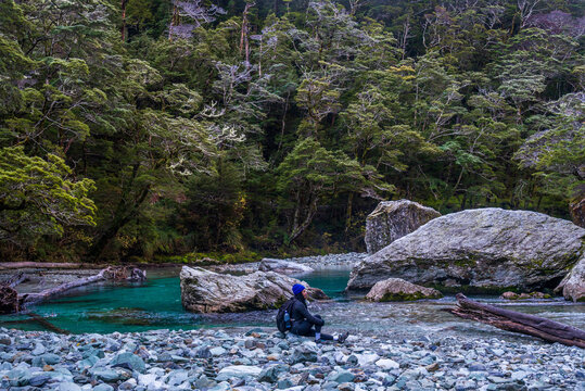 Woman sitting by a rainforest and river