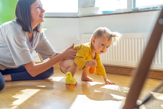 Nanny spends time with baby. Young woman playing with a child