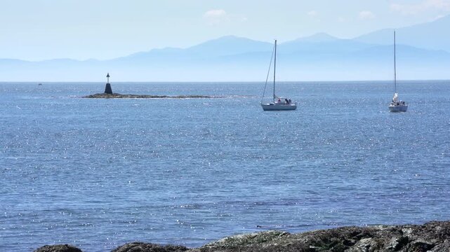 Sailboats Motoring in Sunshine Haro Strait Oak Bay 4K UHD.Sailboats motoring off Cattle Point near Victoria. British Columbia, Canada. 4K, UHD.
