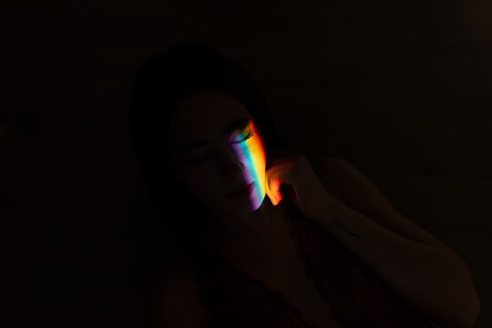 Woman in dark place with colored line
