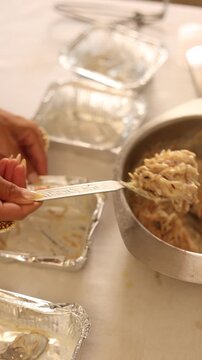 A rich Indian woman packing sweet food for less fortunate people