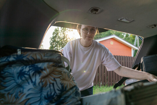 Woman Packing Car Trunk in the Evening.