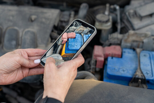 Taking a photo of a car battery with a smartphone.