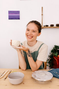 Expressive sculptor with handmade ceramic cup in atelier
