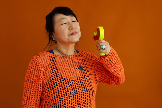 Portrait of stylish female with mini electric fan