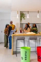 Fotobehang Koken African American family with senior and teens cooking around wood island near green PAPER bin  © wavebreak3