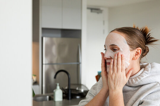 Woman covering face with hands in modern kitchen area