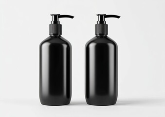 Fototapeta premium Two black, cylindrical pump bottles sit against a white background, side-by-side