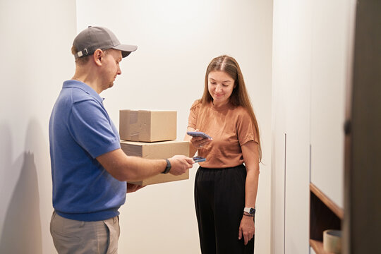 Delivery Person Handing Packages to Woman at Home