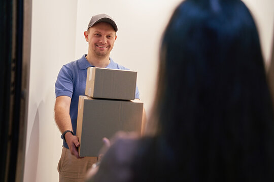 Delivery Person Handing Over Packages at Home Entrance