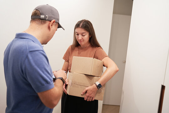 Delivery Person Handing Over Packages to Woman Indoors
