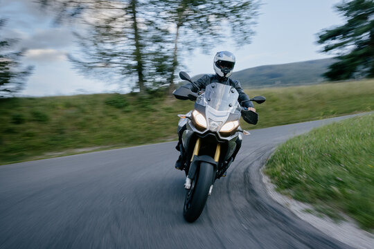Man on sport tour motorcycle in corner.
