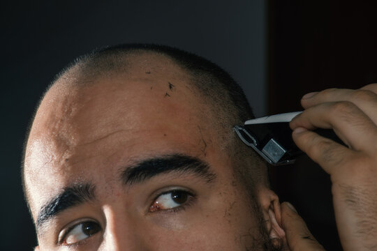 Closeup of bald man giving himself a hair cut