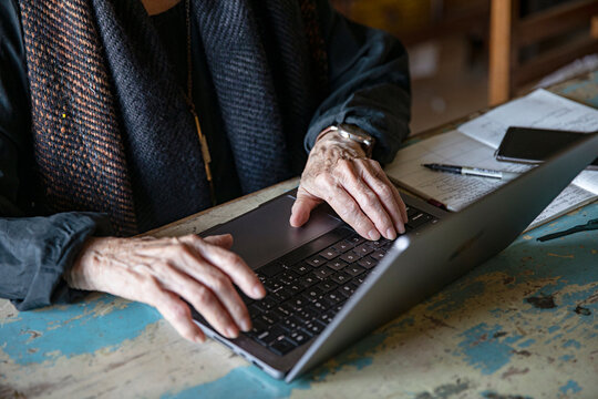 Close up of older hands working at a laptop
