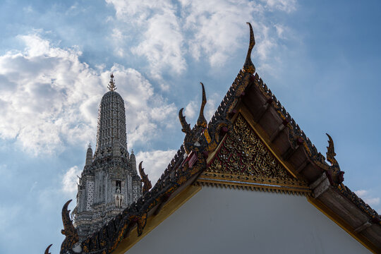 Ornate tiered roof of the Ordination Hall with porcelain Prang towers at Wat Arun, Bangkok