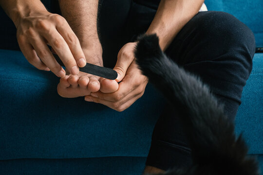 Man Filing Nails During Pedicure 