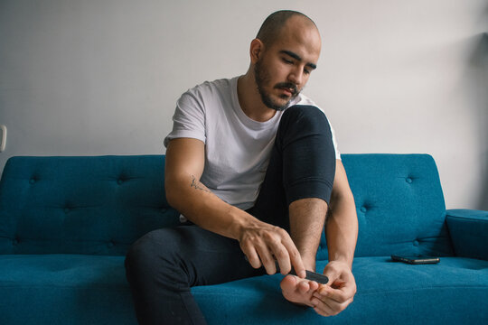 Man Filing Nails During Pedicure 