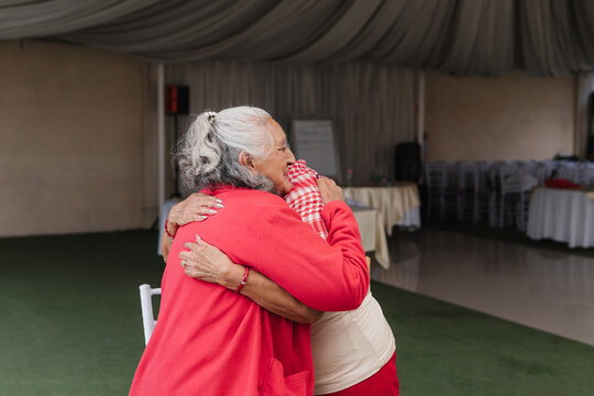 Portrait of two adorable grandmothers hugging.