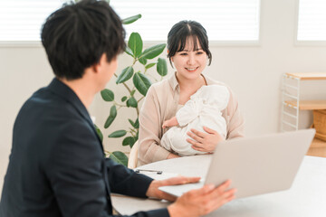 Obraz premium A mother holding a baby receiving advice from a salesman during a door-to-door sales call, a female customer