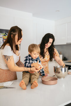 Little boy cooking with his moms at home