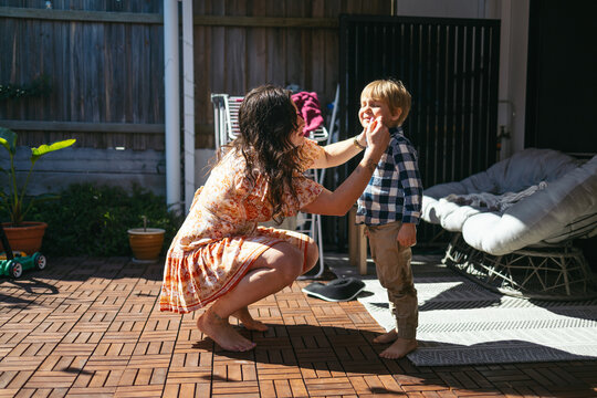 Mother wiping her child's face outdoors