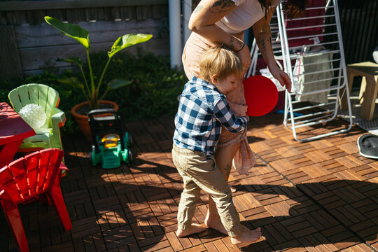 Little boy hugging his mum playing in the backyard
