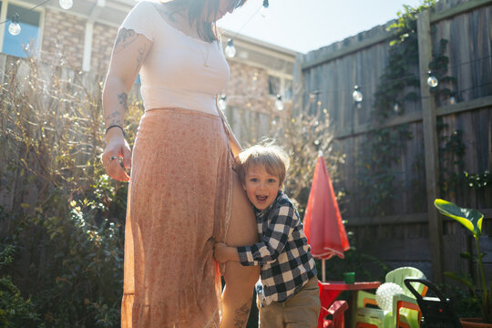 Happy little boy hugging his mum outdoors