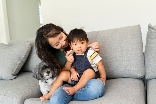 A mom pinching her baby's cheeks