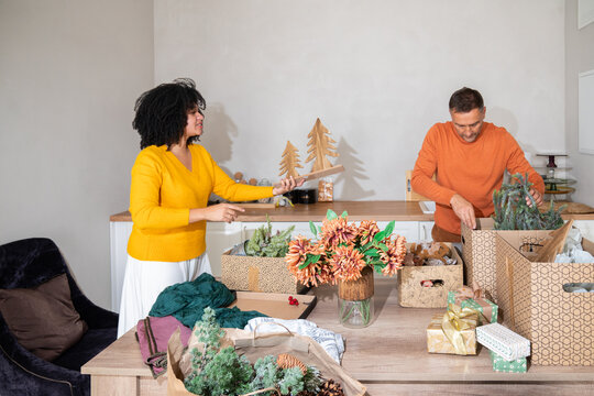 Man and woman organising Christmas decorations in boxes