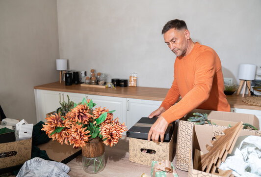 Man organising Christmas decorations in boxes
