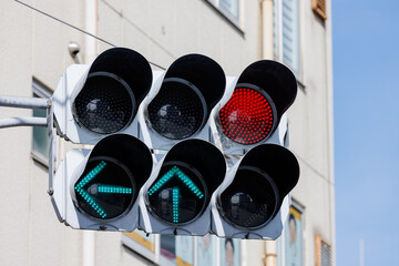 赤信号と左・直進の青矢印が点灯する交通信号機