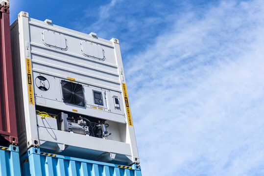 Refrigerated shipping container against blue sky, symbol of global cold chain logistics and maritime transport.