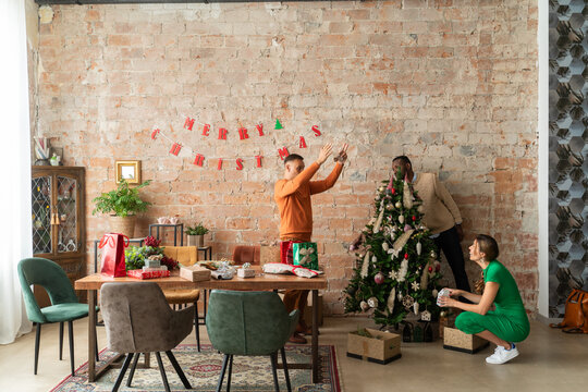 Friends decorating Christmas tree together