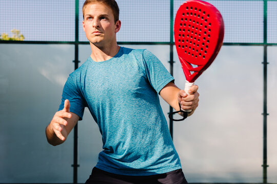 An amateur paddle tennis player focuses during a practice match