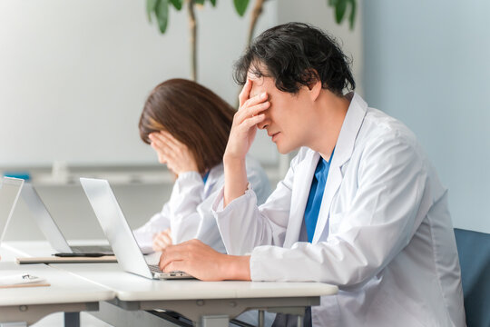 パソコンを見ながら落ち込む,困る,悩む男性医師,ドクター