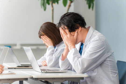Male doctor depressed by medical malpractice trouble (shock, anguish, despair)