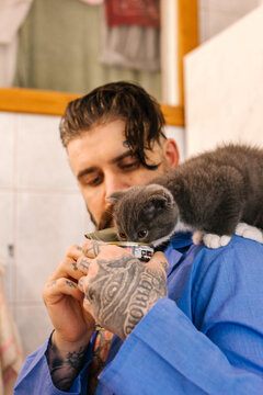 man feeding a kitten