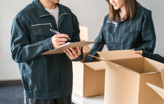 ダンボールに荷物を詰める運送・物流・宅急便・宅配便・流通・配達・宅配業者の作業員