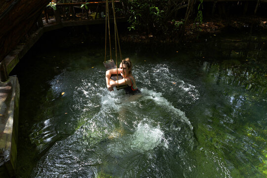 Female tourist swimming in jungle pool, Tulum, Riviera Maya