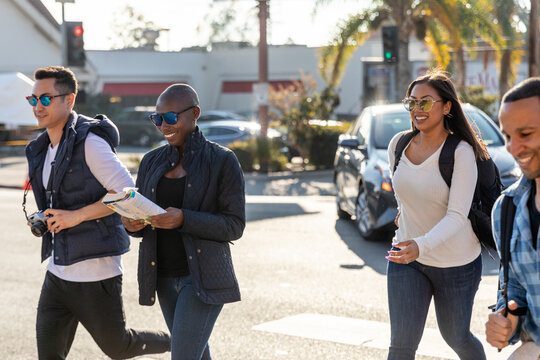 Group of Friends Crossing the Street with Maps and Camera in Han