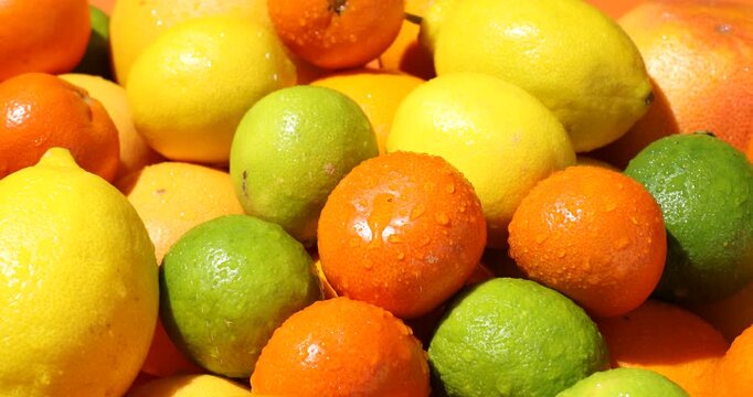 Spraying water onto different ripe citrus fruits, closeup