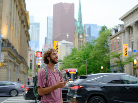 Man using smartphone walking in Montreal city, Canada 
