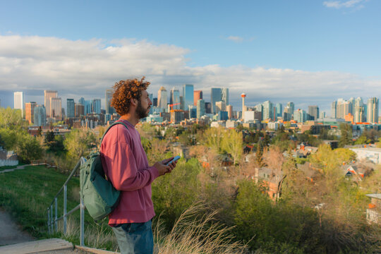 Man using smartphone on the background of Calgary cityscape 