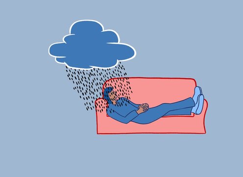 A woman lays on a sofa thinking