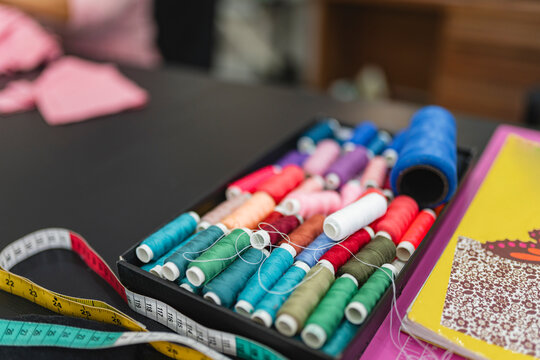 Colorful thread spools on a sewing table