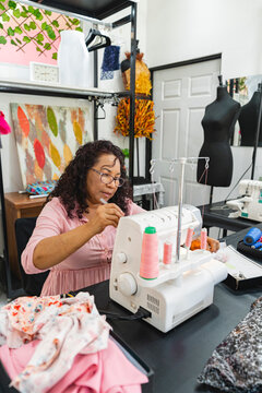 Woman sewing with an overlock machine in workshop