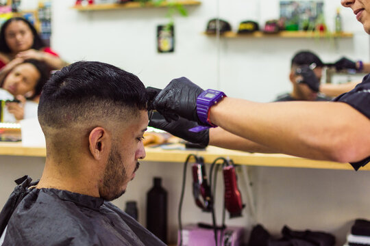 Barber wearing latex gloves cutting hair