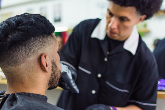 Close up of barber shaving man's mustache