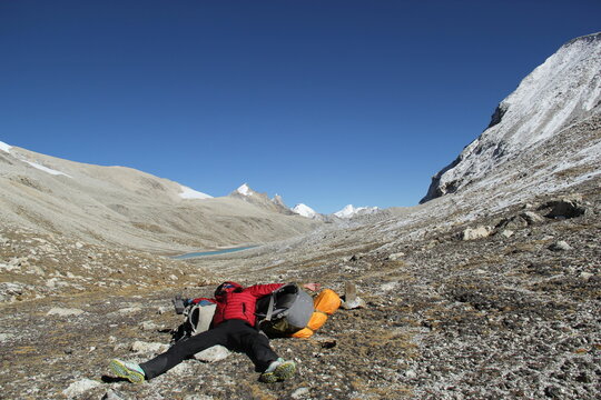 Tired hiker sprawled out on top of a mountain pass.