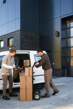 Men unload parcels from the car